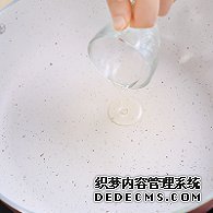 步驟圖:電陶爐開大火，煎炒鍋中倒入少許油。