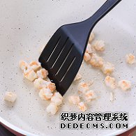 步驟圖:油熱后倒入蝦仁，用鍋鏟翻炒2分鐘至變色，盛出碗中備